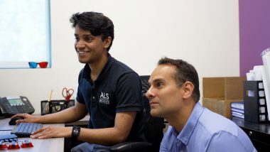 Fernando Vieira sits at a computer terminal with researcher Alan Premasiri.