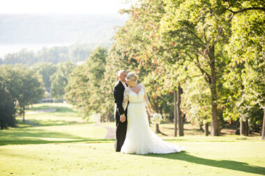 A wedding portrait of a bride and groom that looks to be taken on a golf course. 