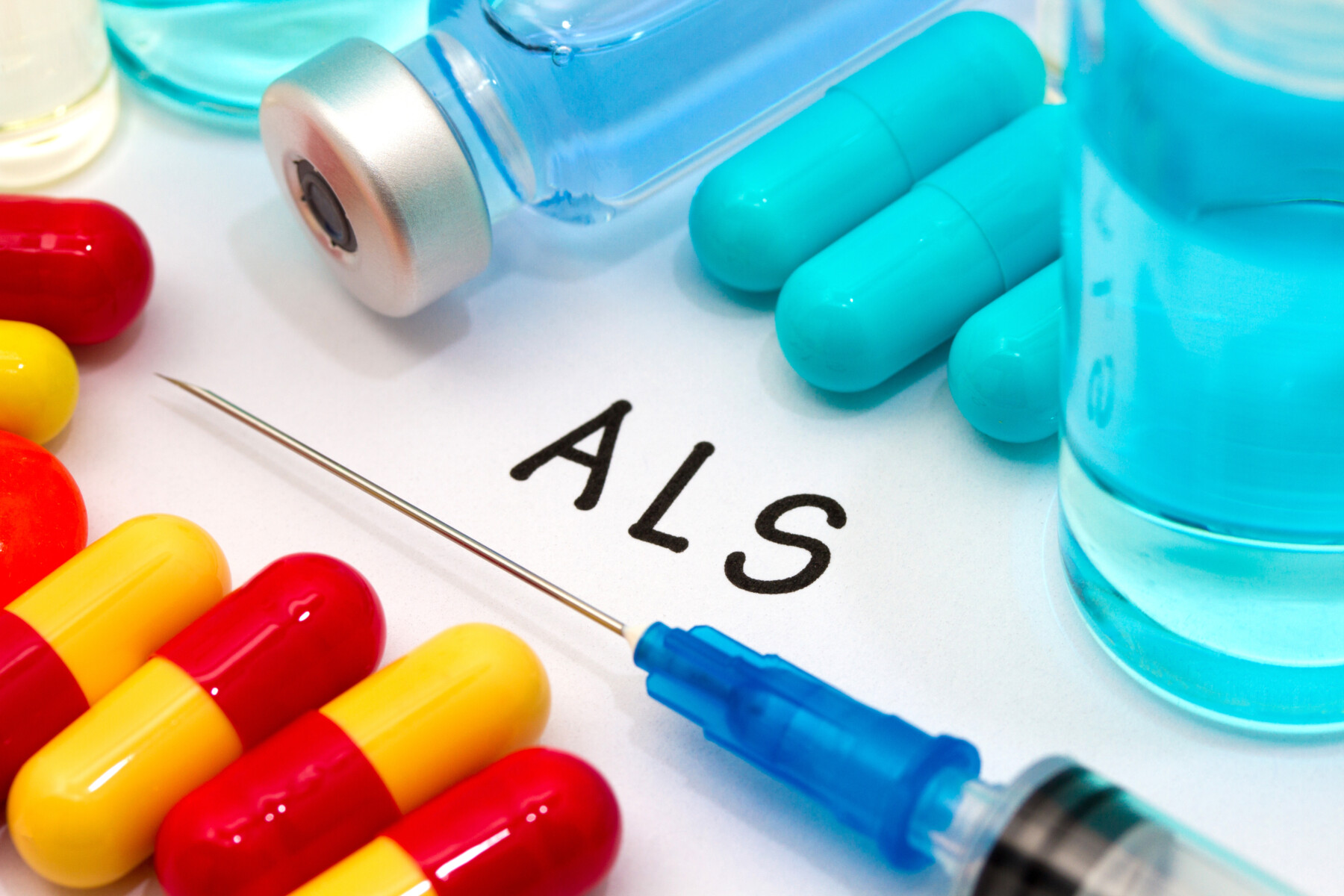 Medications and vials on to top of paper that says ALS