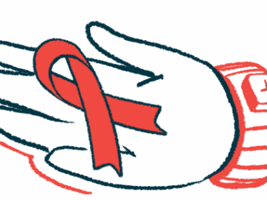 A hand holds a red awareness ribbon.