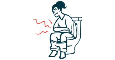 A woman sits on a toilet holding her stomach.