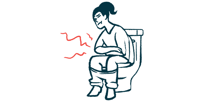 A woman sits on a toilet holding her stomach.