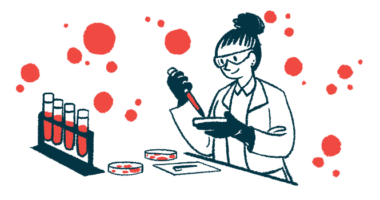 A researcher in a lab uses a dropper to apply material to a petri dish.