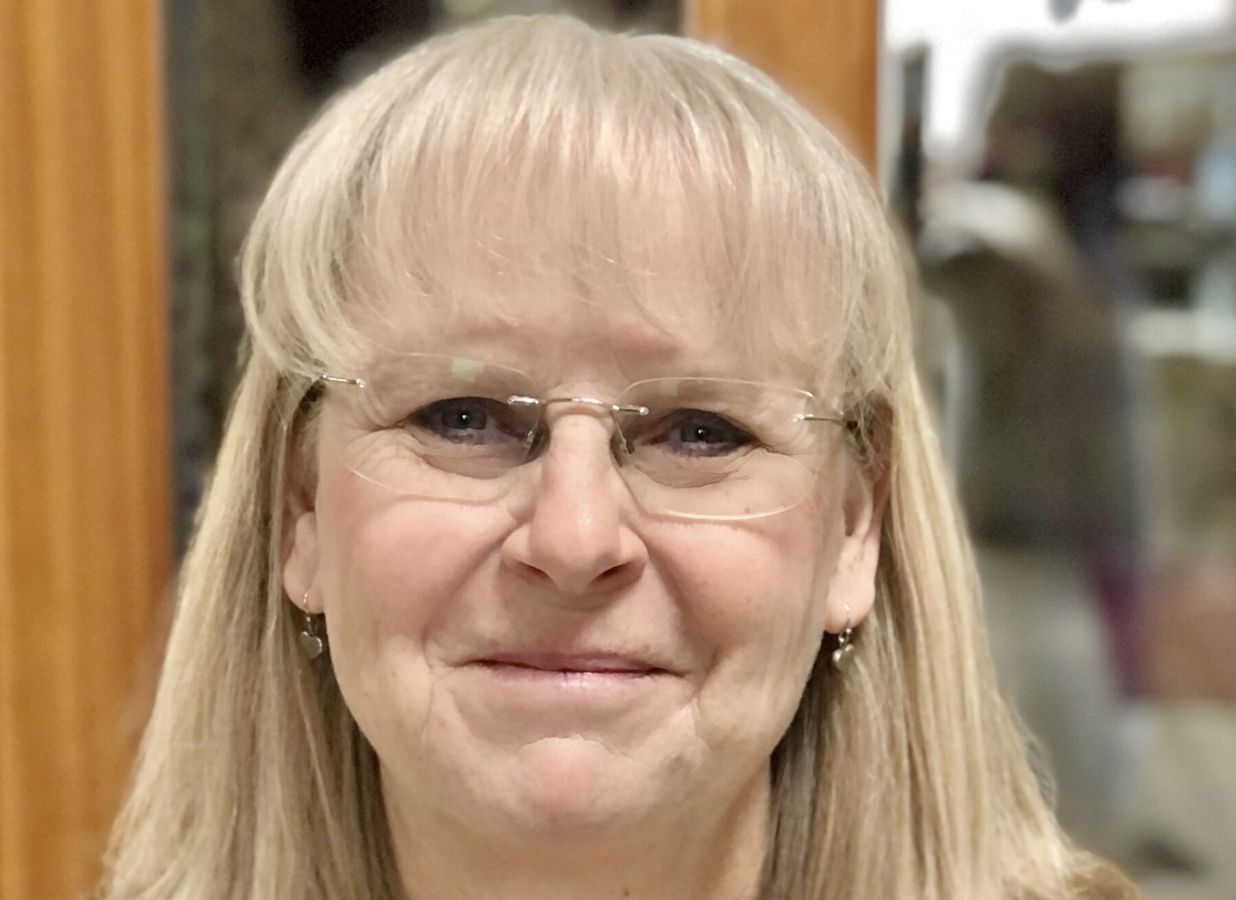 A very large close-up of a woman's face. She is smiling broadly.