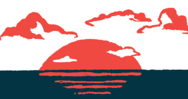 The sun sets over the ocean, with clouds in the background.