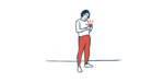 A person stands while using their smartphone.