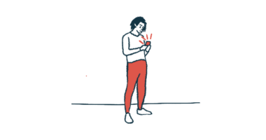 A person stands while using their smartphone.