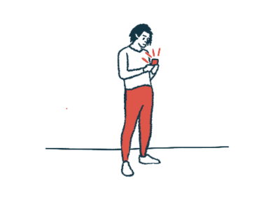 A person stands while using their smartphone.