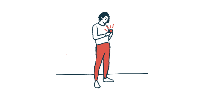 A person stands while using their smartphone.